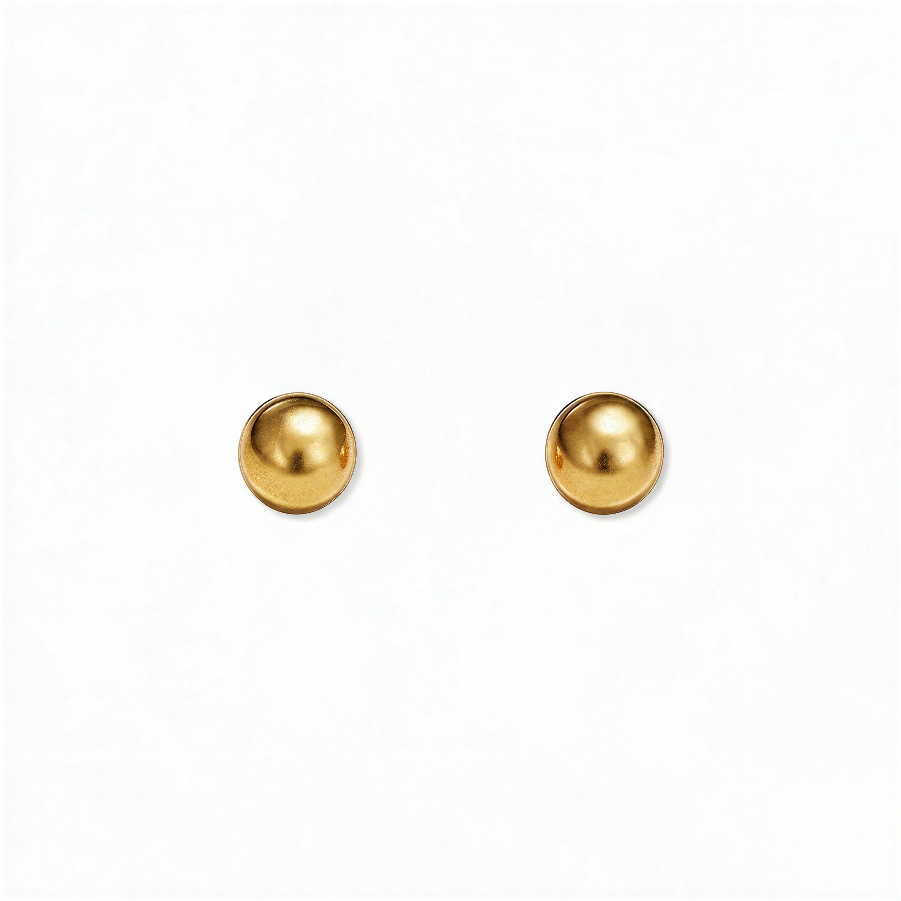 A pair of Ball Stud Earrings 4mm by Skōsh Jewelry, featuring smooth, highly polished round gold balls on post backs, displayed against a white background.