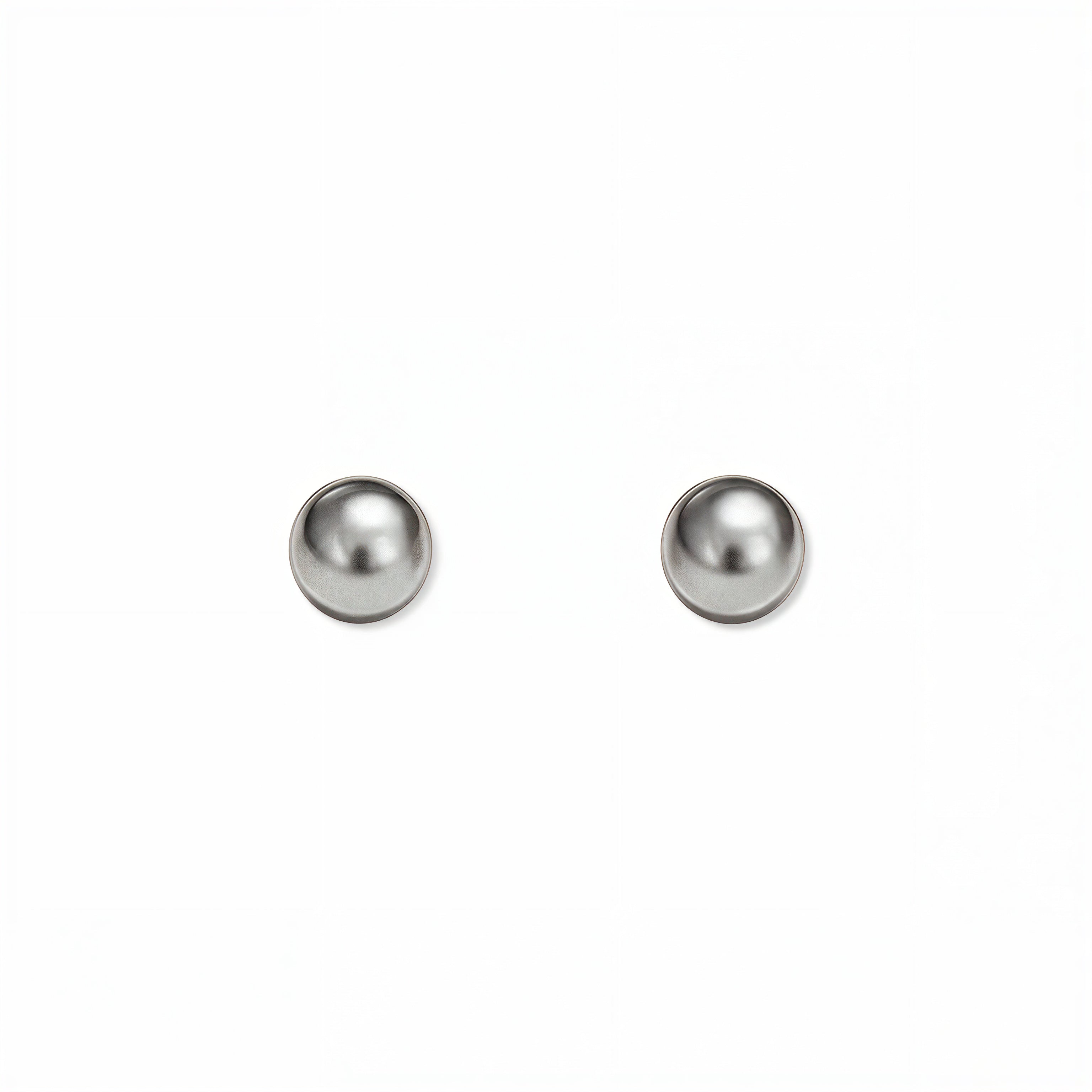 A pair of Ball Stud Earrings 4mm by Skōsh Jewelry, featuring smooth, highly polished round sterling silver balls on post backs, displayed against a white background.