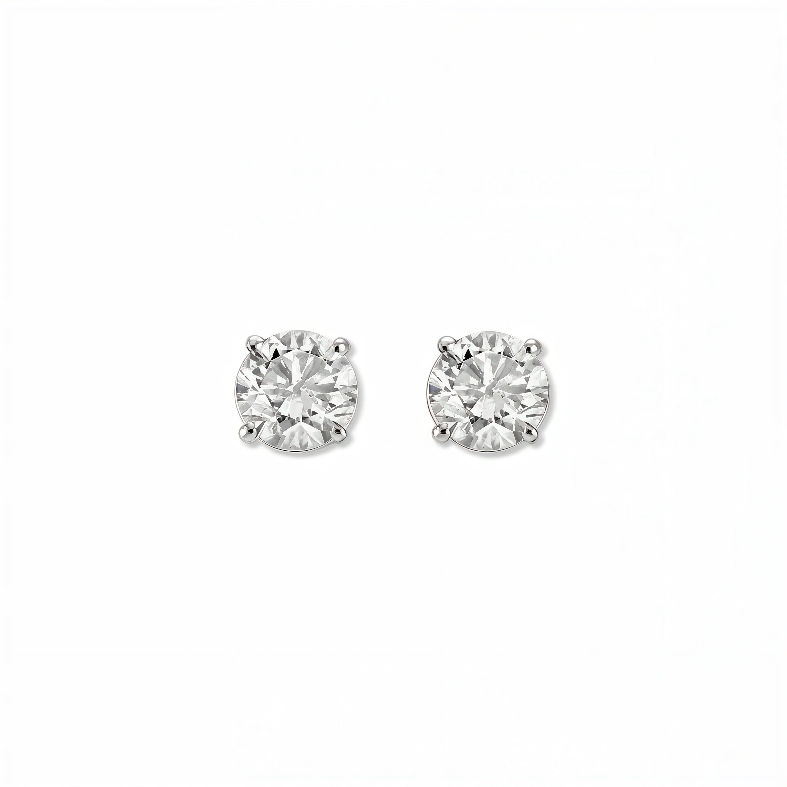 A pair of Round White Cubic Zirconia Stud Earrings 6mm by Skōsh Jewelry, featuring round, faceted clear stones in a four-prong sterling silver setting, displayed against a white background.