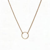 An Infinity Circle Necklace by Skōsh Jewelry, featuring a single open circle pendant attached at both sides to a delicate gold cable chain, displayed against a white background.