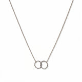 A Friendship Interlocking Circles Necklace by Skōsh Jewelry, featuring two small interlocking circles of equal size on a fine sterling silver chain, displayed against a white background.