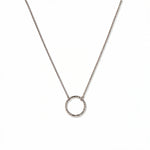 An Aura Hammered Circle Necklace by Skōsh Jewelry, featuring an open circle with a hammered, textured finish on a fine sterling silver chain, displayed against a white background.
