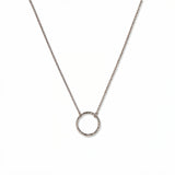 An Aura Hammered Circle Necklace by Skōsh Jewelry, featuring an open circle with a hammered, textured finish on a fine sterling silver chain, displayed against a white background.