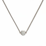 A Skōsh Kids Smiley Face Necklace by Skōsh Jewelry, featuring a small round smiley face charm set sideways on a fine sterling silver chain, displayed against a white background.