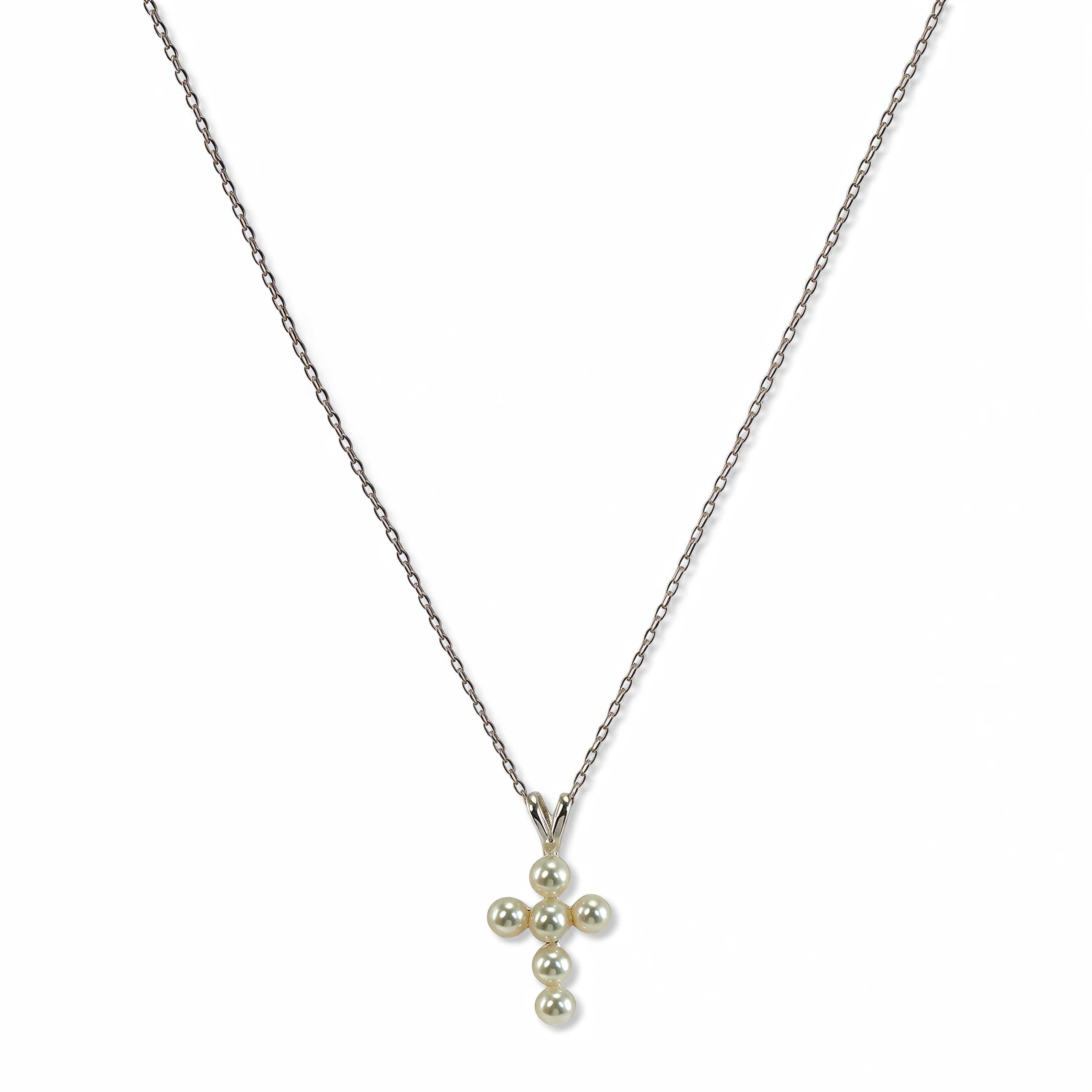 A Skōsh Kids Freshwater Pearl Cross Pendant Necklace by Skōsh Jewelry, featuring a small cross pendant made of tiny white pearl beads hanging from a fine sterling silver chain, displayed against a white background.