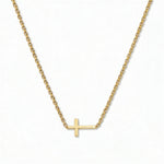 A Skōsh Kids Inline Sideways Cross Necklace by Skōsh Jewelry, featuring a slim polished cross set sideways on a fine gold chain, displayed against a white background.