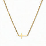 A Skōsh Kids Inline Sideways Cross Necklace by Skōsh Jewelry, featuring a slim polished cross set sideways on a fine gold chain, displayed against a white background.