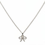 A Skōsh Kids Ribbon Bow Pendant Necklace by Skōsh Jewelry, featuring a dainty ribbon bow pendant on a fine sterling silver chain, displayed against a white background.
