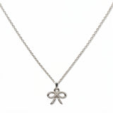 A Skōsh Kids Ribbon Bow Pendant Necklace by Skōsh Jewelry, featuring a dainty ribbon bow pendant on a fine sterling silver chain, displayed against a white background.