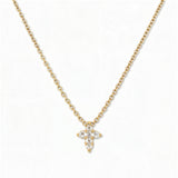 A Skōsh Kids Mini Cross Necklace in White Cubic Zirconia by Skōsh Jewelry, featuring a petite cross of clear marquise and round stones on a fine 14K gold over sterling silver chain, displayed against a white background.