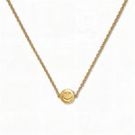A Skōsh Kids Smiley Face Necklace by Skōsh Jewelry, featuring a small round smiley face charm set sideways on a fine gold chain, displayed against a white background.