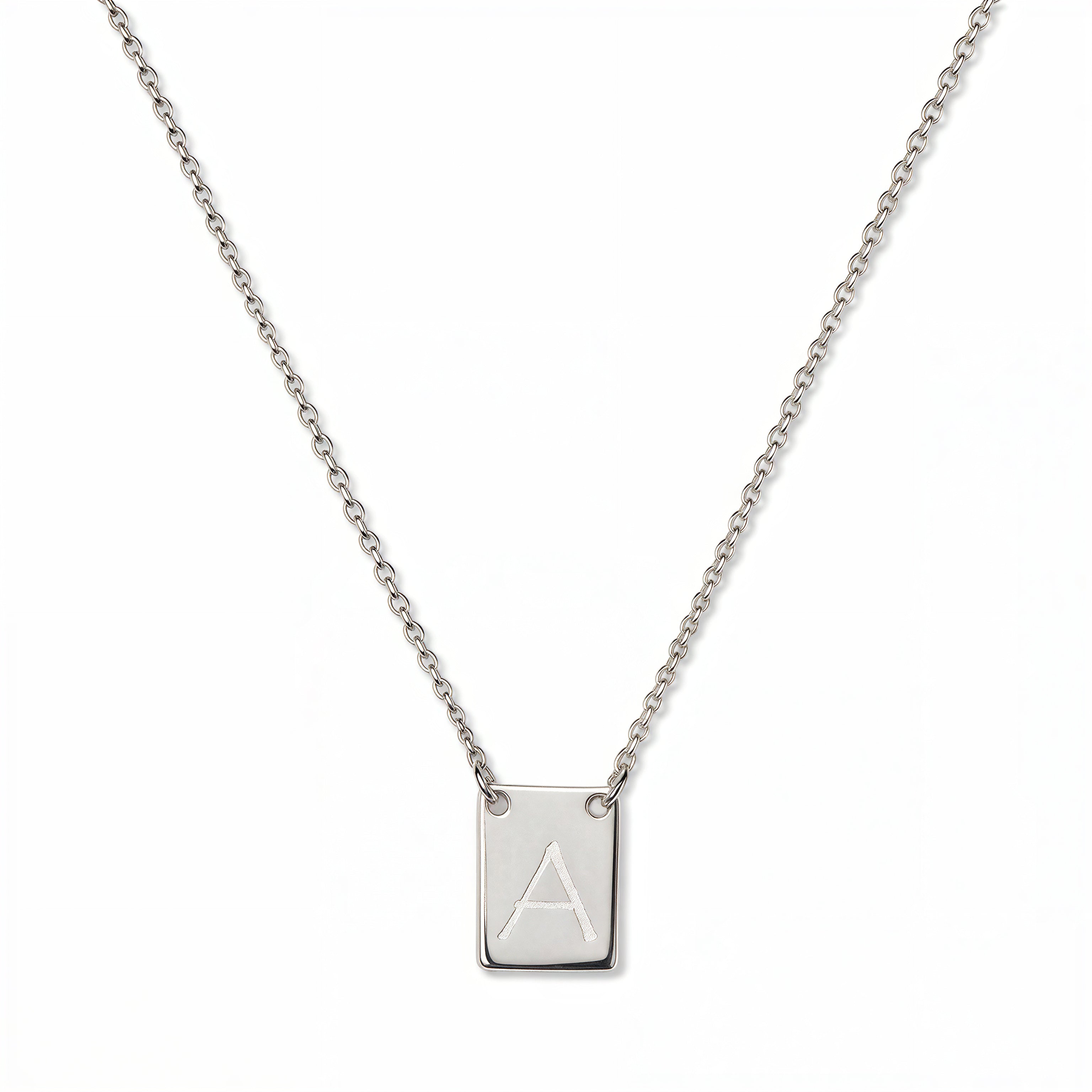 An Engraved Initial Necklace Letter A by Skōsh Jewelry, featuring a small rectangular tag engraved with the letter A on a fine sterling silver chain, displayed against a white background.