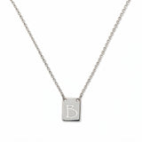 An Engraved Initial Necklace Letter B by Skōsh Jewelry, featuring a small rectangular tag engraved with the letter B on a fine sterling silver chain, displayed against a white background.