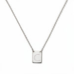 An Engraved Initial Necklace Letter C by Skōsh Jewelry, featuring a small rectangular tag engraved with the letter C on a fine sterling silver chain, displayed against a white background.