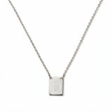 An Engraved Initial Necklace Letter D by Skōsh Jewelry, featuring a small rectangular tag engraved with the letter D on a fine sterling silver chain, displayed against a white background.