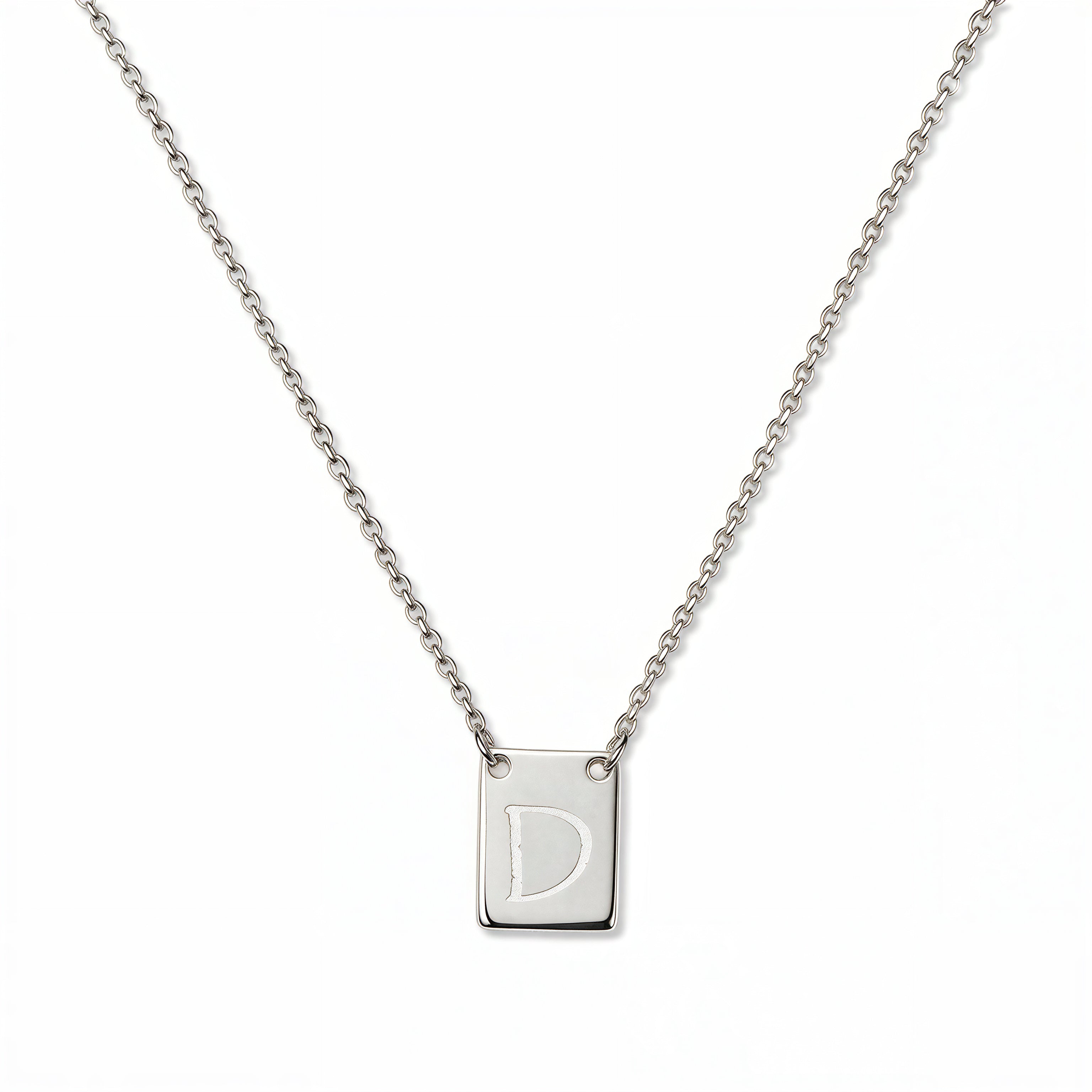 An Engraved Initial Necklace Letter D by Skōsh Jewelry, featuring a small rectangular tag engraved with the letter D on a fine sterling silver chain, displayed against a white background.