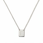 An Engraved Initial Necklace Letter E by Skōsh Jewelry, featuring a small rectangular tag engraved with the letter E on a fine sterling silver chain, displayed against a white background.