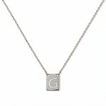 An Engraved Initial Necklace Letter G by Skōsh Jewelry, featuring a small rectangular tag engraved with the letter G on a fine sterling silver chain, displayed against a white background.