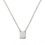 An Engraved Initial Necklace Letter H by Skōsh Jewelry, featuring a small rectangular tag engraved with the letter H on a fine sterling silver chain, displayed against a white background.