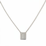 An Engraved Initial Necklace Letter I by Skōsh Jewelry, featuring a small rectangular tag engraved with the letter I on a fine sterling silver chain, displayed against a white background.