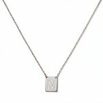 An Engraved Initial Necklace Letter M by Skōsh Jewelry, featuring a small rectangular tag engraved with the letter M on a fine sterling silver chain, displayed against a white background.