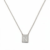 An Engraved Initial Necklace Letter N by Skōsh Jewelry, featuring a small rectangular tag engraved with the letter N on a fine sterling silver chain, displayed against a white background.
