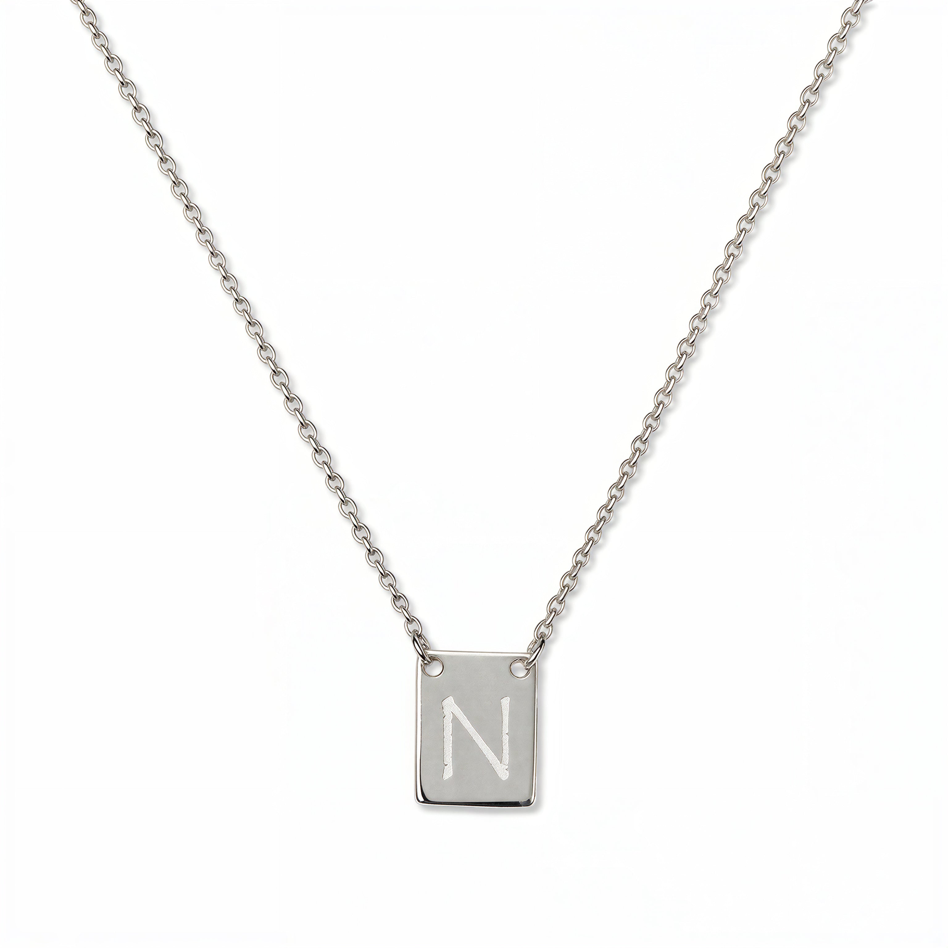 An Engraved Initial Necklace Letter N by Skōsh Jewelry, featuring a small rectangular tag engraved with the letter N on a fine sterling silver chain, displayed against a white background.