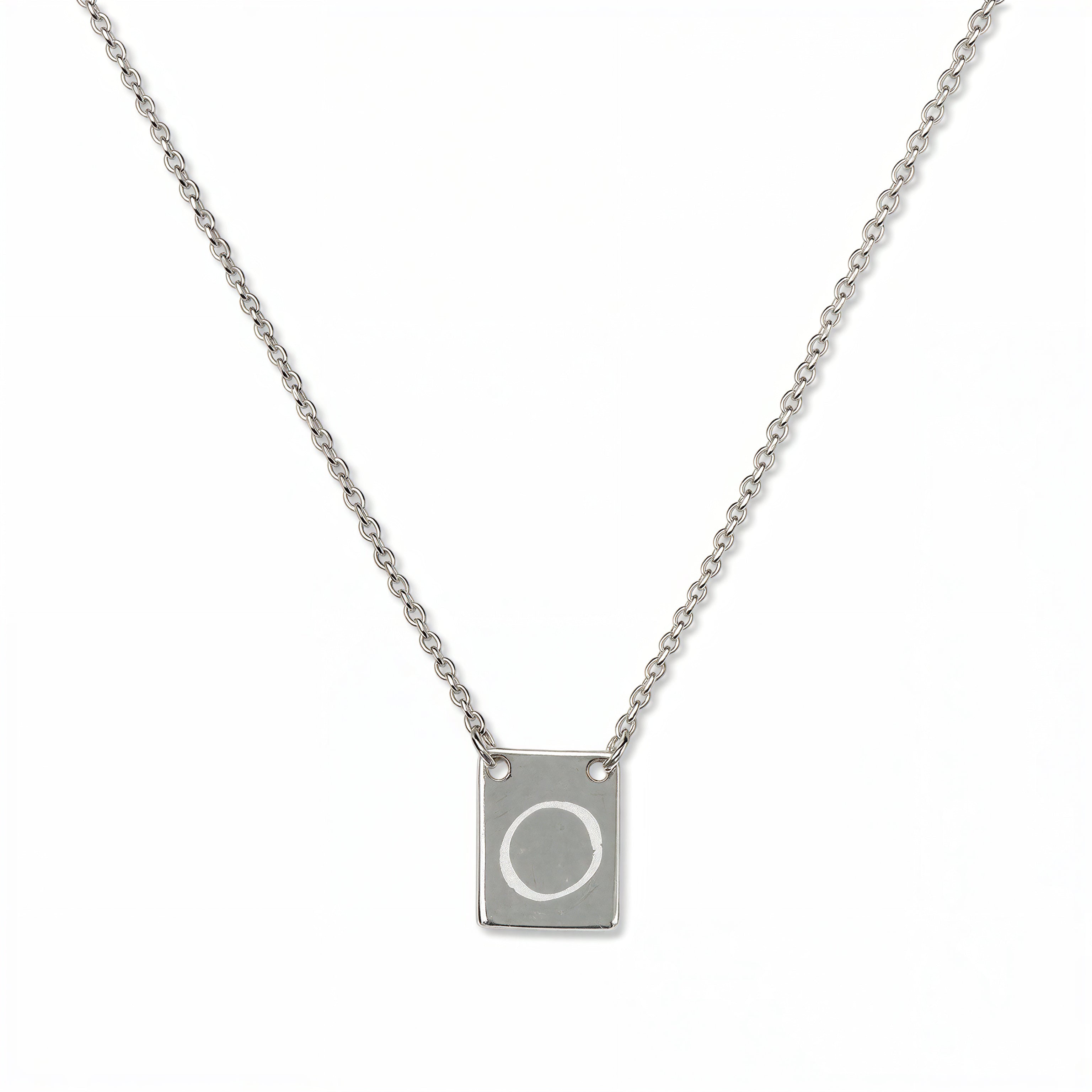 An Engraved Initial Necklace Letter O by Skōsh Jewelry, featuring a small rectangular tag engraved with the letter O on a fine sterling silver chain, displayed against a white background.