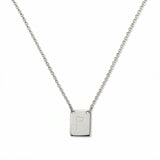 An Engraved Initial Necklace Letter P by Skōsh Jewelry, featuring a small rectangular tag engraved with the letter P on a fine sterling silver chain, displayed against a white background.