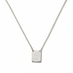 An Engraved Initial Necklace Letter S by Skōsh Jewelry, featuring a small rectangular tag engraved with the letter S on a fine sterling silver chain, displayed against a white background.
