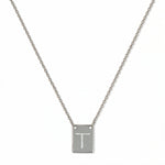 An Engraved Initial Necklace Letter T by Skōsh Jewelry, featuring a small rectangular tag engraved with the letter T on a fine sterling silver chain, displayed against a white background.