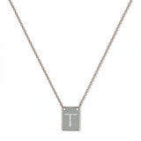 An Engraved Initial Necklace Letter T by Skōsh Jewelry, featuring a small rectangular tag engraved with the letter T on a fine sterling silver chain, displayed against a white background.