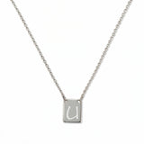 An Engraved Initial Necklace Letter U by Skōsh Jewelry, featuring a small rectangular tag engraved with the letter U on a fine sterling silver chain, displayed against a white background.
