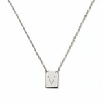 An Engraved Initial Necklace Letter V by Skōsh Jewelry, featuring a small rectangular tag engraved with the letter V on a fine sterling silver chain, displayed against a white background.