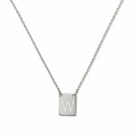 An Engraved Initial Necklace Letter W by Skōsh Jewelry, featuring a small rectangular tag engraved with the letter W on a fine sterling silver chain, displayed against a white background.