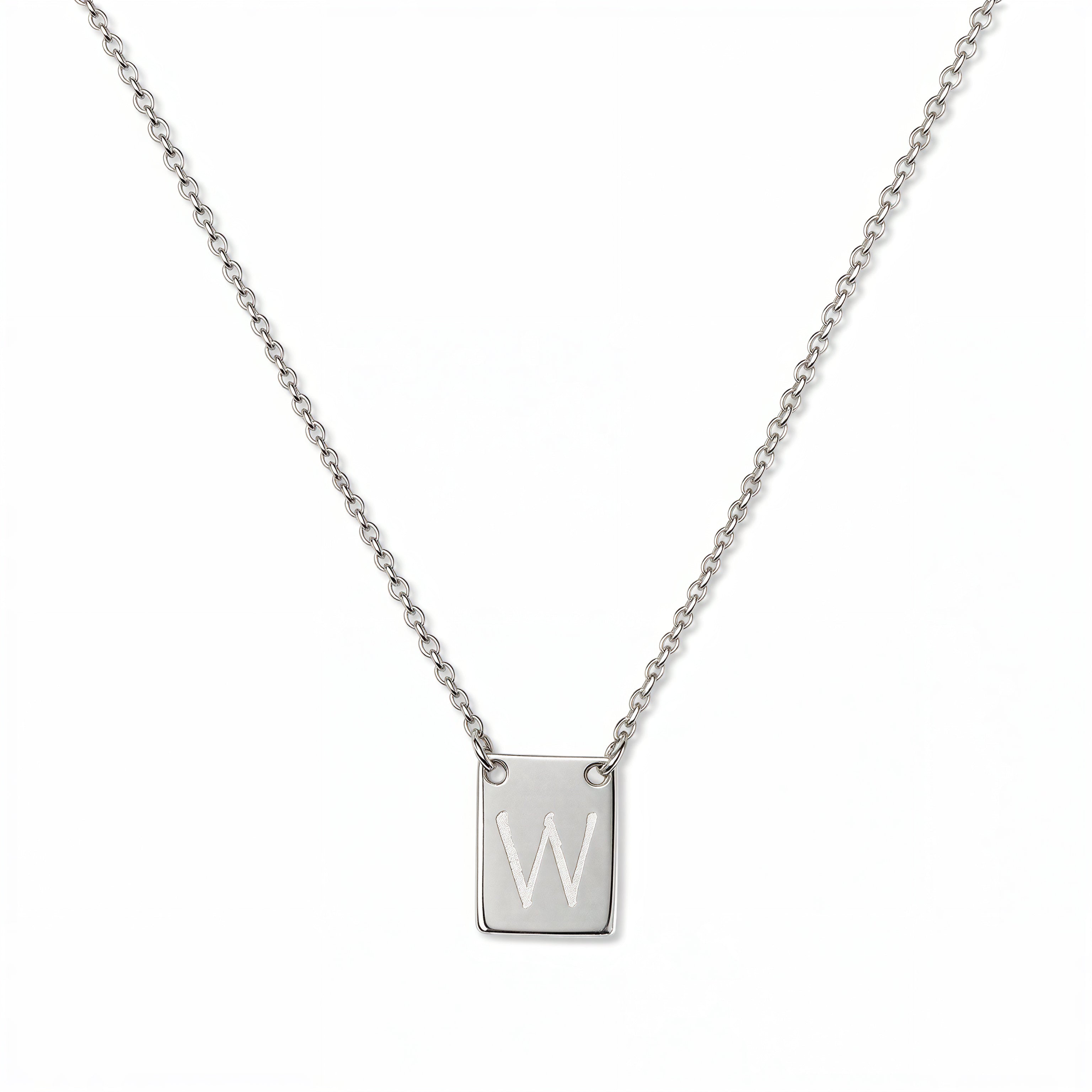 An Engraved Initial Necklace Letter W by Skōsh Jewelry, featuring a small rectangular tag engraved with the letter W on a fine sterling silver chain, displayed against a white background.