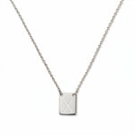 An Engraved Initial Necklace Letter X by Skōsh Jewelry, featuring a small rectangular tag engraved with the letter X on a fine sterling silver chain, displayed against a white background.