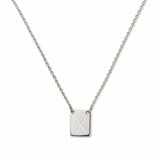 An Engraved Initial Necklace Letter X by Skōsh Jewelry, featuring a small rectangular tag engraved with the letter X on a fine sterling silver chain, displayed against a white background.