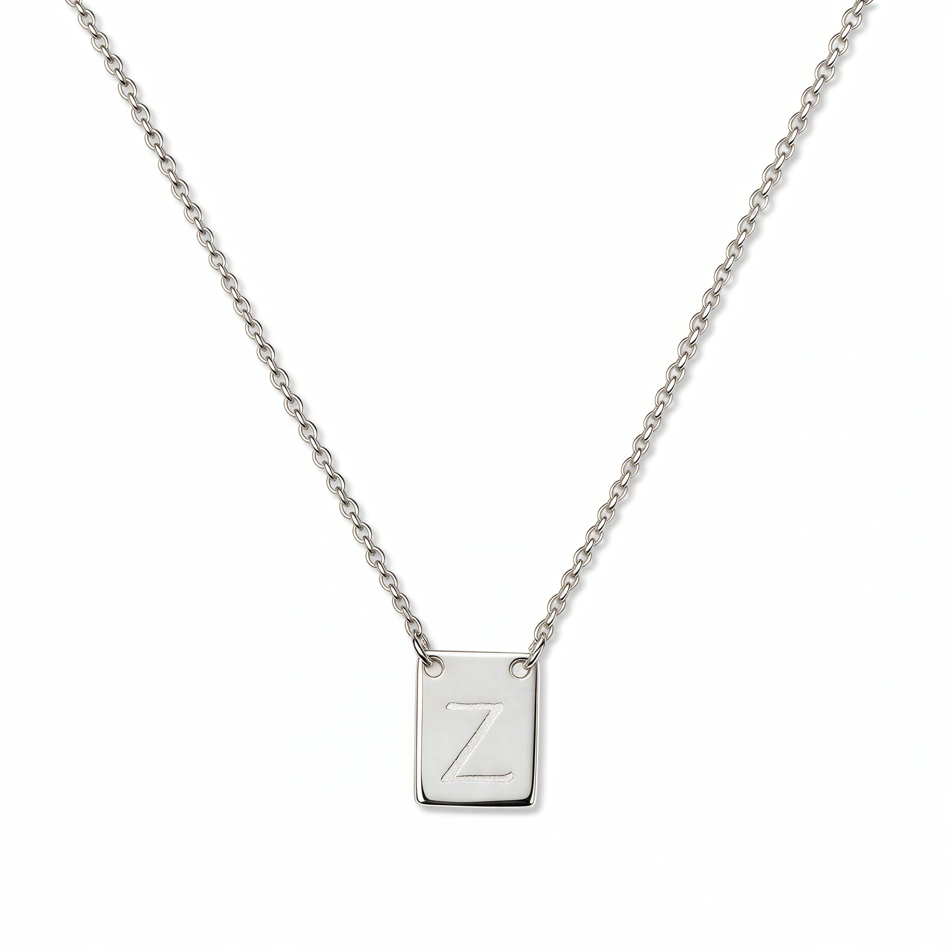 An Engraved Initial Necklace Letter Z by Skōsh Jewelry, featuring a small rectangular tag engraved with the letter Z on a fine sterling silver chain, displayed against a white background.