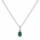 A Skōsh Kids May Birthstone Oval Emerald Cubic Zirconia Necklace by Skōsh Jewelry, featuring an oval faceted green stone in a prong setting on a fine sterling silver chain, displayed against a white background.