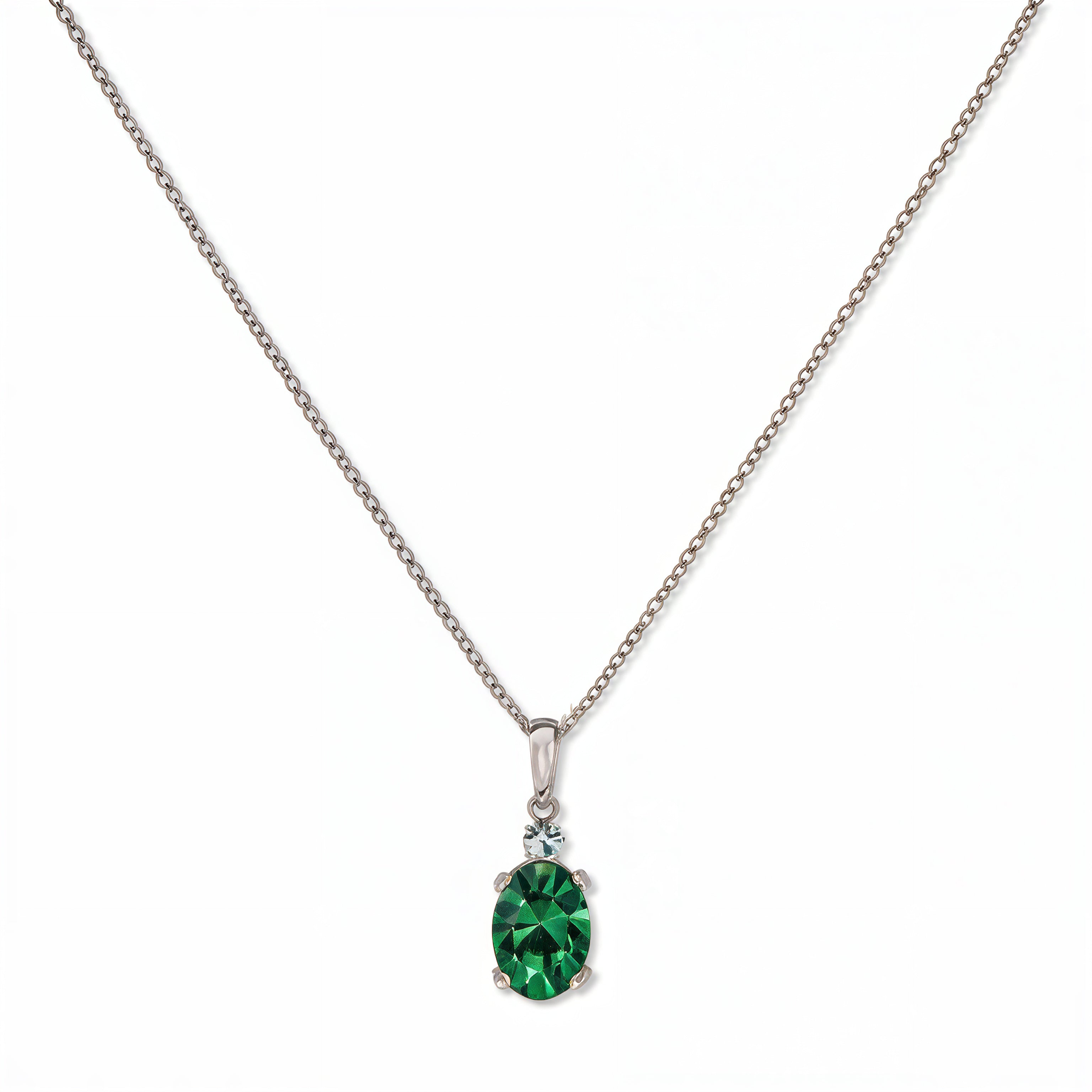 A Skōsh Kids May Birthstone Oval Emerald Cubic Zirconia Necklace by Skōsh Jewelry, featuring an oval faceted green stone in a prong setting on a fine sterling silver chain, displayed against a white background.