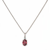 A Skōsh Kids July Birthstone Oval Ruby Cubic Zirconia Necklace by Skōsh Jewelry, featuring an oval faceted red stone in a prong setting on a fine sterling silver chain, displayed against a white background.
