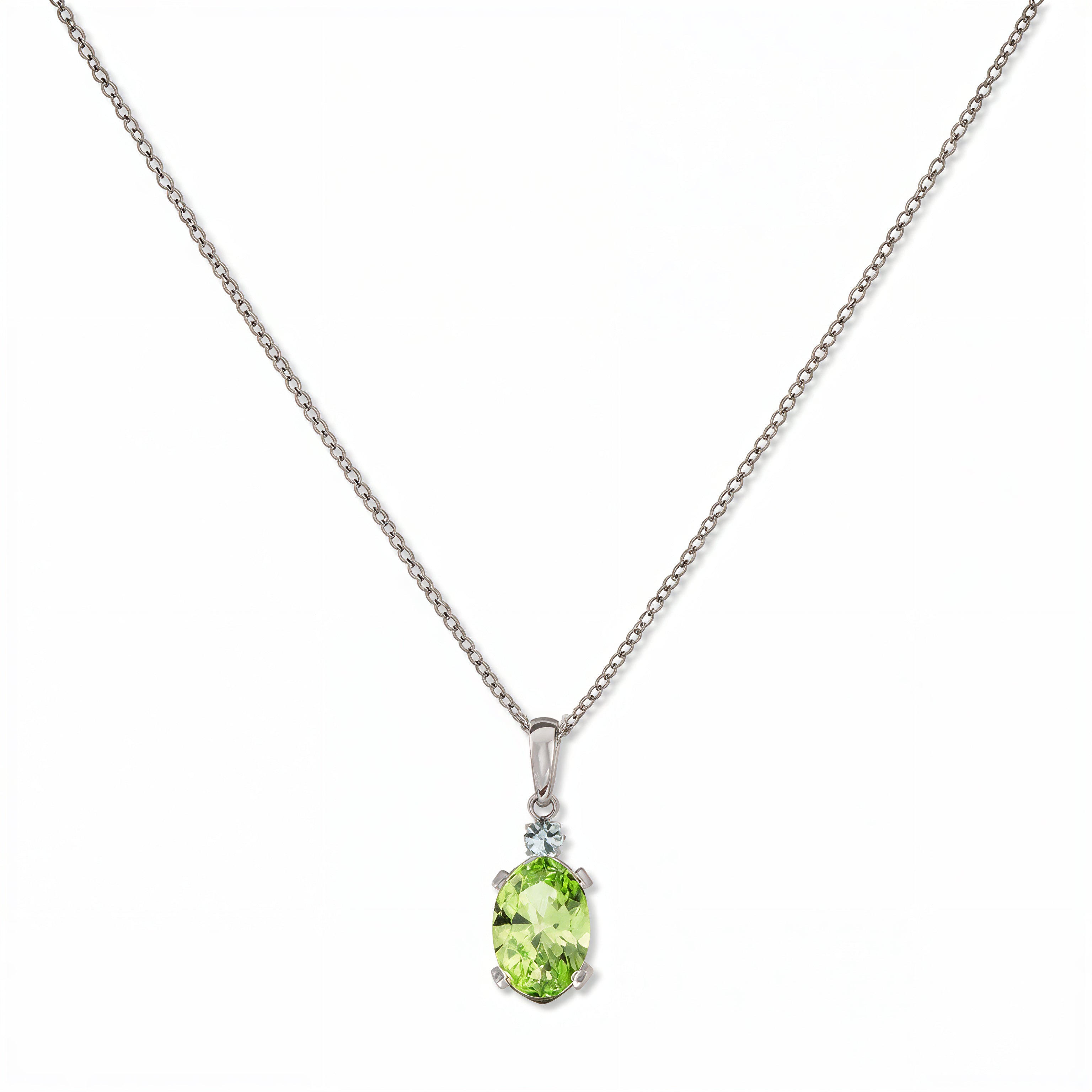 A Skōsh Kids August Birthstone Oval Peridot Cubic Zirconia Necklace by Skōsh Jewelry, featuring an oval faceted light green stone in a prong setting on a fine sterling silver chain, displayed against a white background.