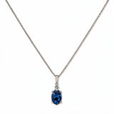 A Skōsh Kids September Birthstone Oval Sapphire Cubic Zirconia Necklace by Skōsh Jewelry, featuring an oval faceted deep blue stone in a prong setting on a fine sterling silver chain, displayed against a white background.