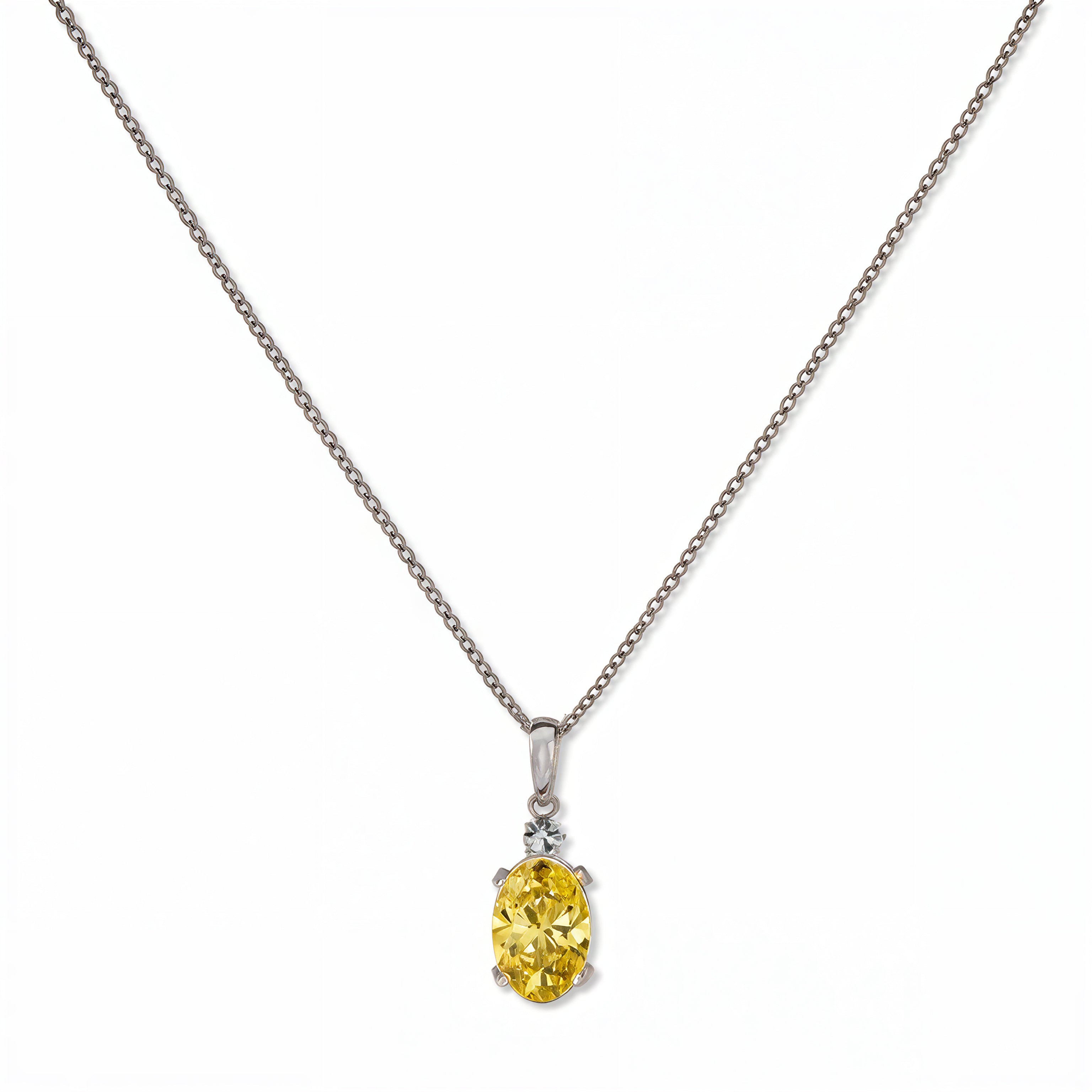 A Skōsh Kids November Birthstone Oval Citrine Cubic Zirconia Necklace by Skōsh Jewelry, featuring an oval faceted yellow stone in a prong setting on a fine sterling silver chain, displayed against a white background.