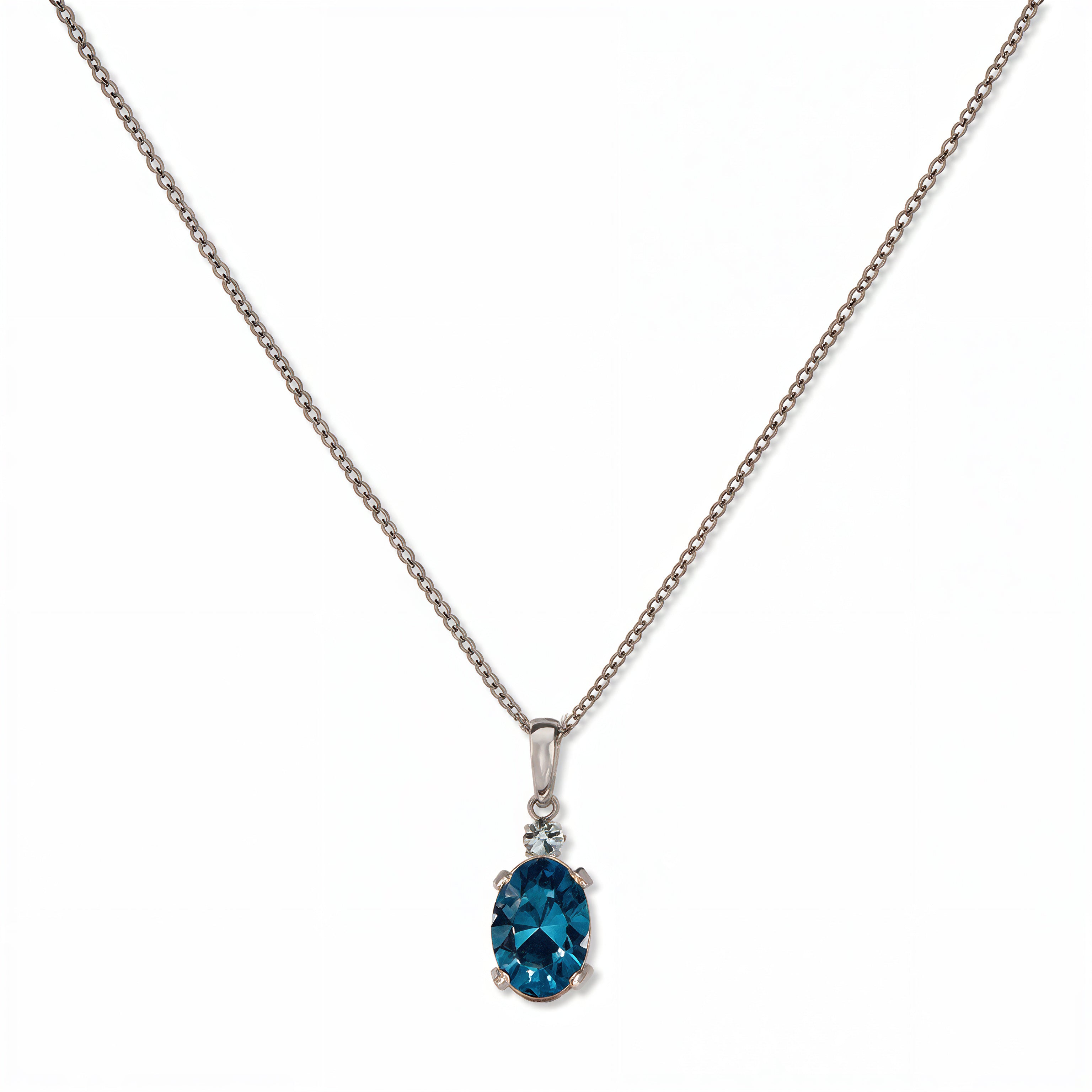 A Skōsh Kids December Birthstone Oval Aqua Cubic Zirconia Necklace by Skōsh Jewelry, featuring an oval faceted blue stone in a prong setting on a fine sterling silver chain, displayed against a white background.