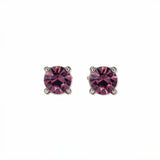 A pair of February Birthstone Round Amethyst Cubic Zirconia Stud Earrings by Skōsh Jewelry, featuring faceted purple round stones in a four-prong sterling silver setting, displayed against a white background.