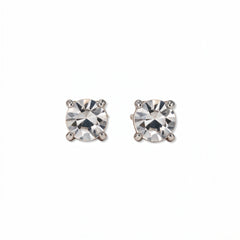 A pair of April Birthstone Round White Cubic Zirconia Stud Earrings by Skōsh Jewelry, featuring faceted clear round stones in a four-prong sterling silver setting, displayed against a white background.