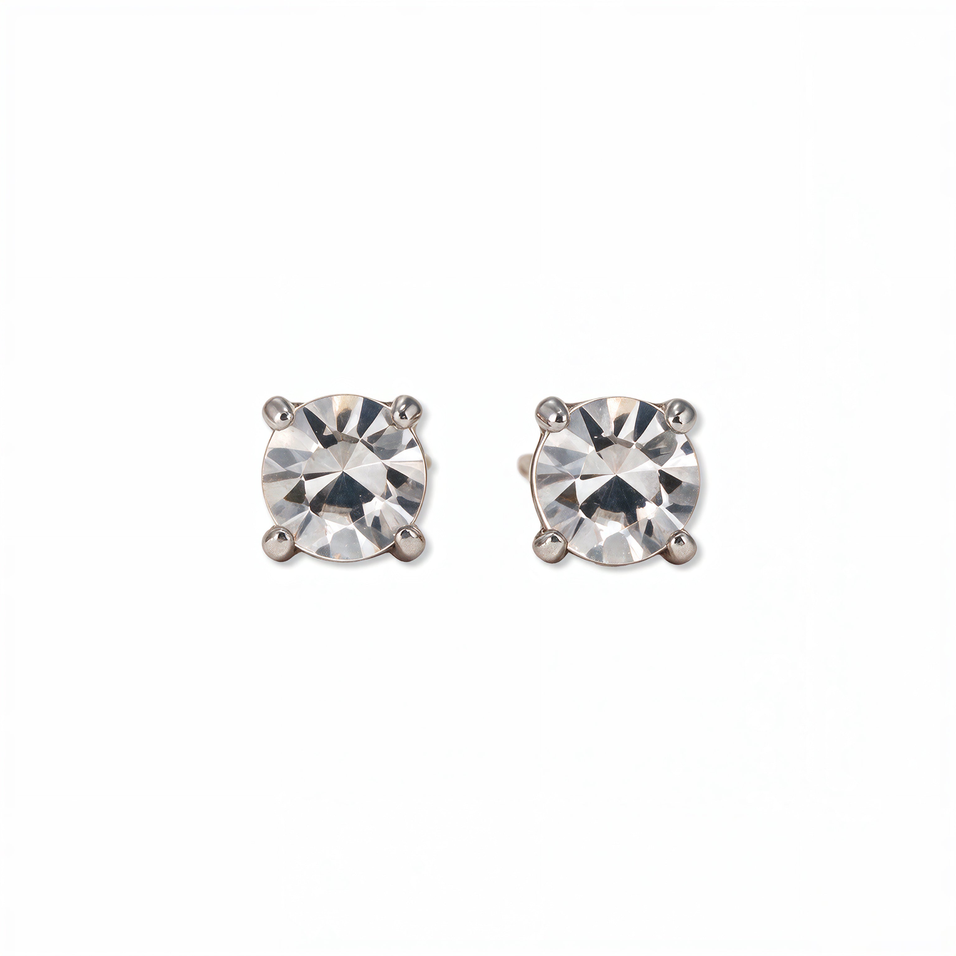 A pair of April Birthstone Round White Cubic Zirconia Stud Earrings by Skōsh Jewelry, featuring faceted clear round stones in a four-prong sterling silver setting, displayed against a white background.