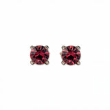 A pair of July Birthstone Round Ruby Cubic Zirconia Stud Earrings by Skōsh Jewelry, featuring faceted red round stones in a four-prong sterling silver setting, displayed against a white background.